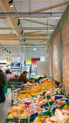 Clientes miran verduras iluminadas con soluciones para productos frescos de Philips