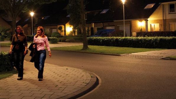 Dos mujeres caminan por una calle alumbrada con luz blanca de Philips