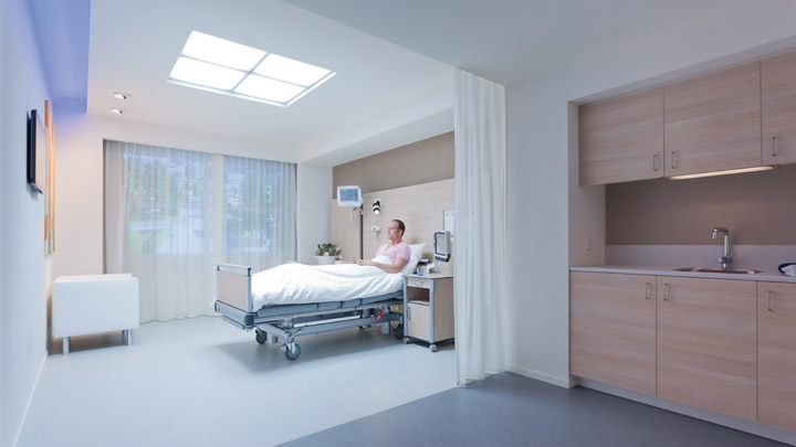 Enfermera en una habitación con iluminación tenue auscultando a un paciente - iluminación para hospitales